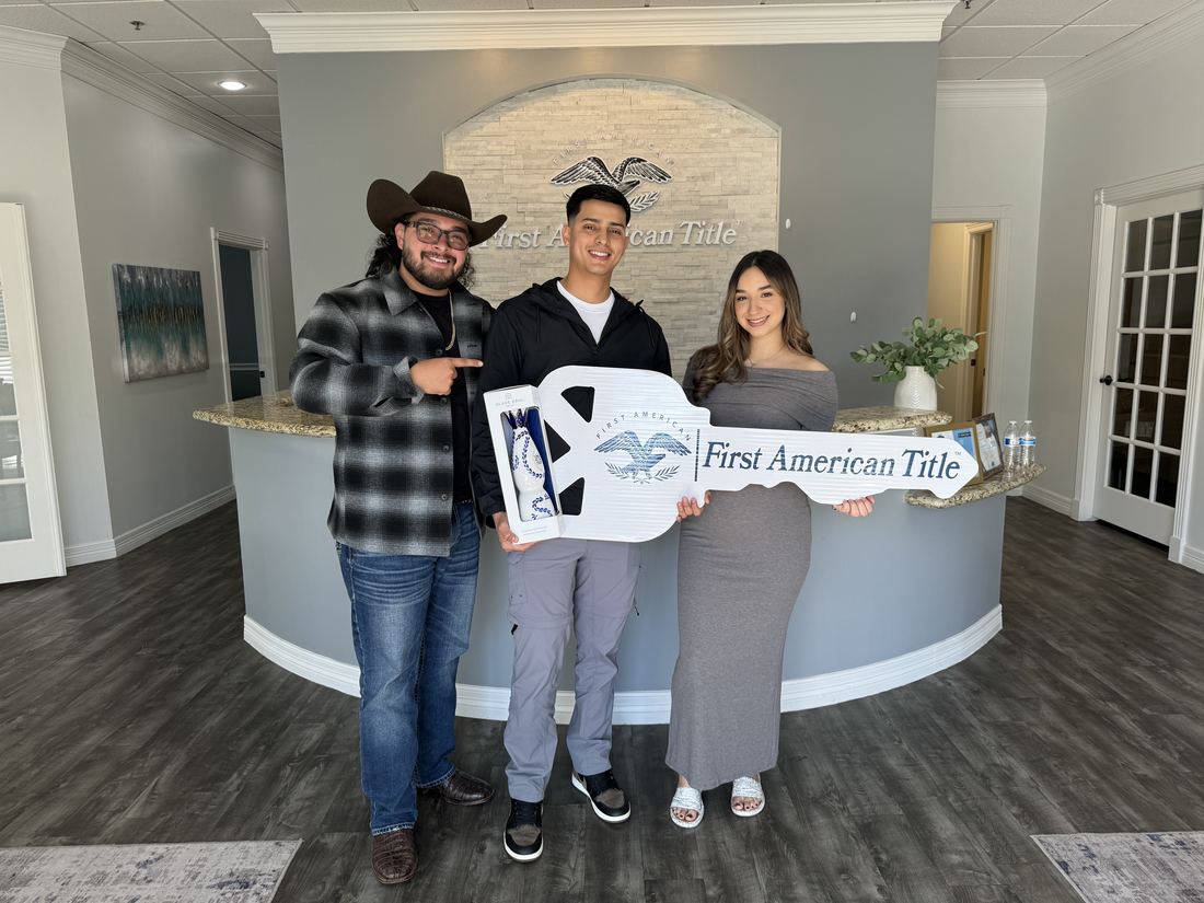 Clients holding a SOLD sign with Adrian Arizmendi