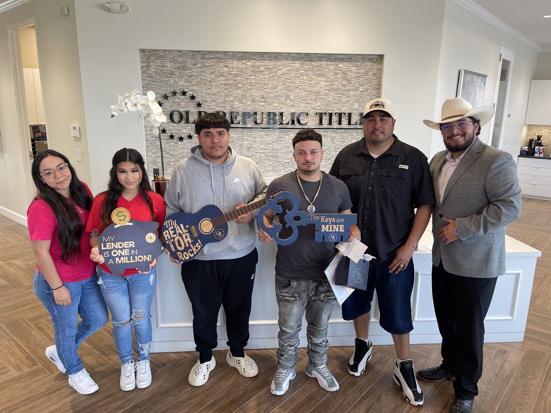 New homeowners at title company with Adrian Arizmendi